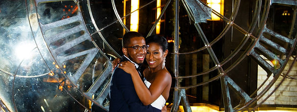 Couple embracing in front of a lit geometric installation at an event planning showcase at night.