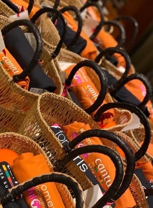 Multiple wicker baskets containing folded orange towels with branded labels.